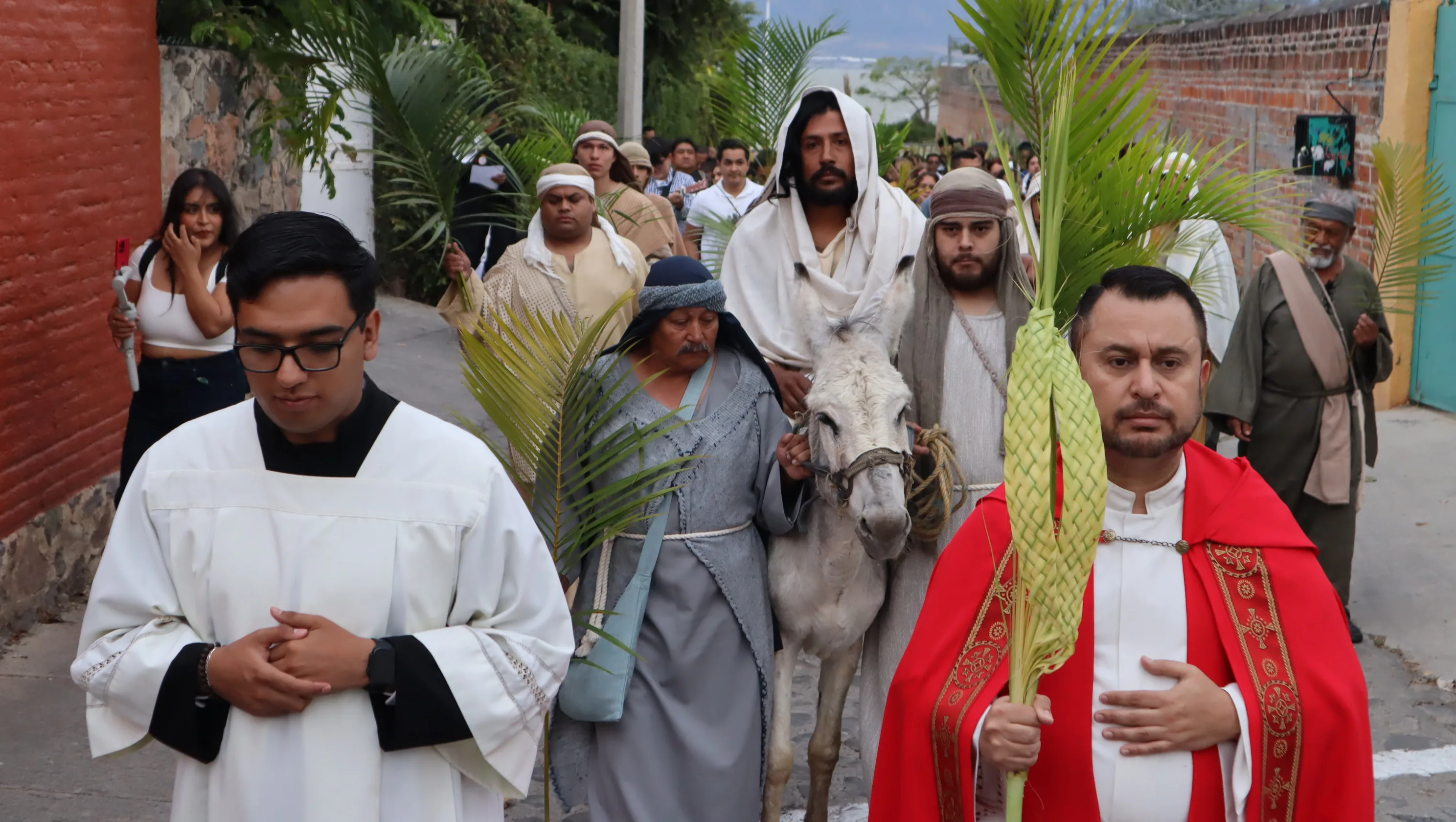 El cura de San Antonio con el elenco de Pasión de Cristo San Antonio durante la procesión de Domingo de Ramos. Foto: D. Arturo Ortega.