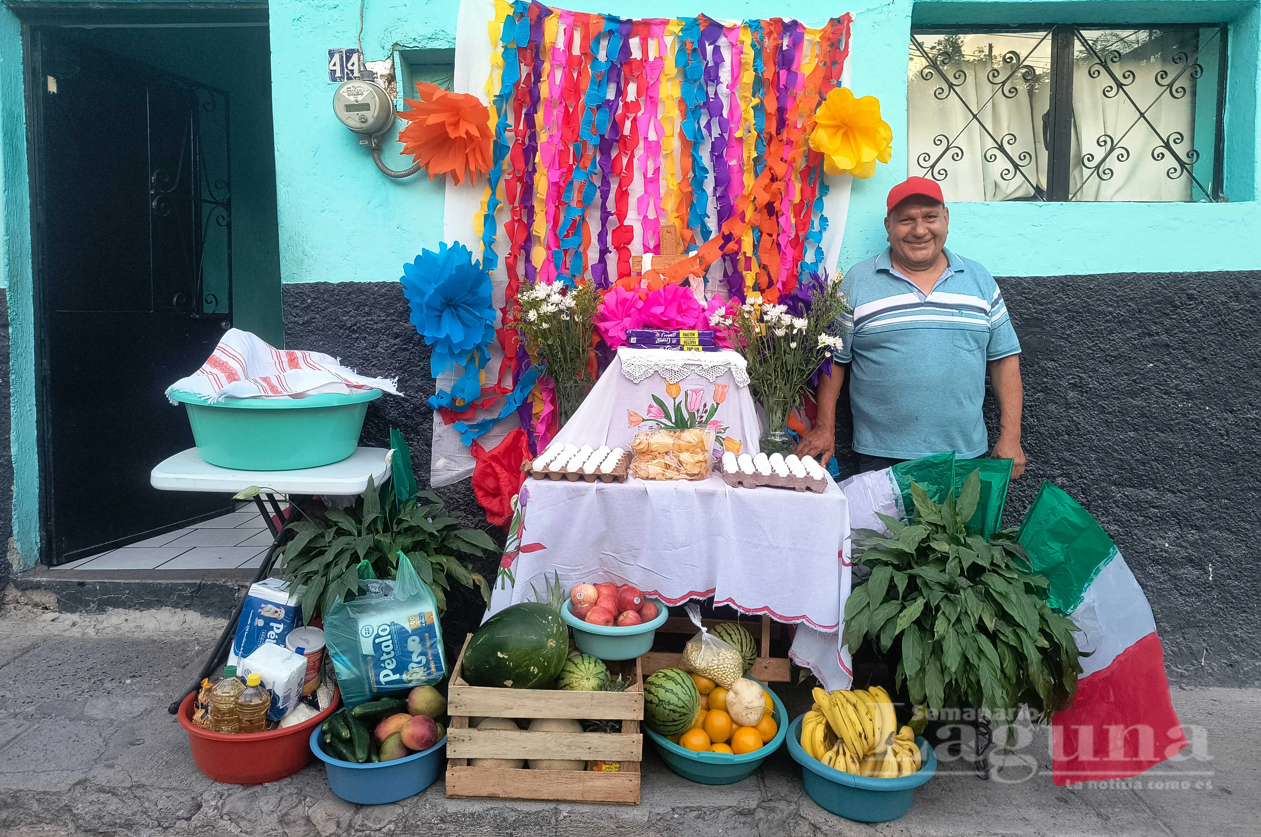 Un vecino del barrio de San Sebastián posa junto a su altar, decorado con pan tradicional, abarrotes y frutas. Foto: Domingo Márquez.