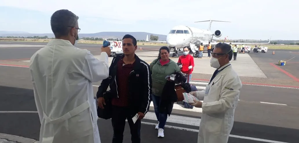 Personal de salud aplica un filtro de prevención sanitaria a viajeros tras su llegada al aeropuerto. Foto: Cortesía.
