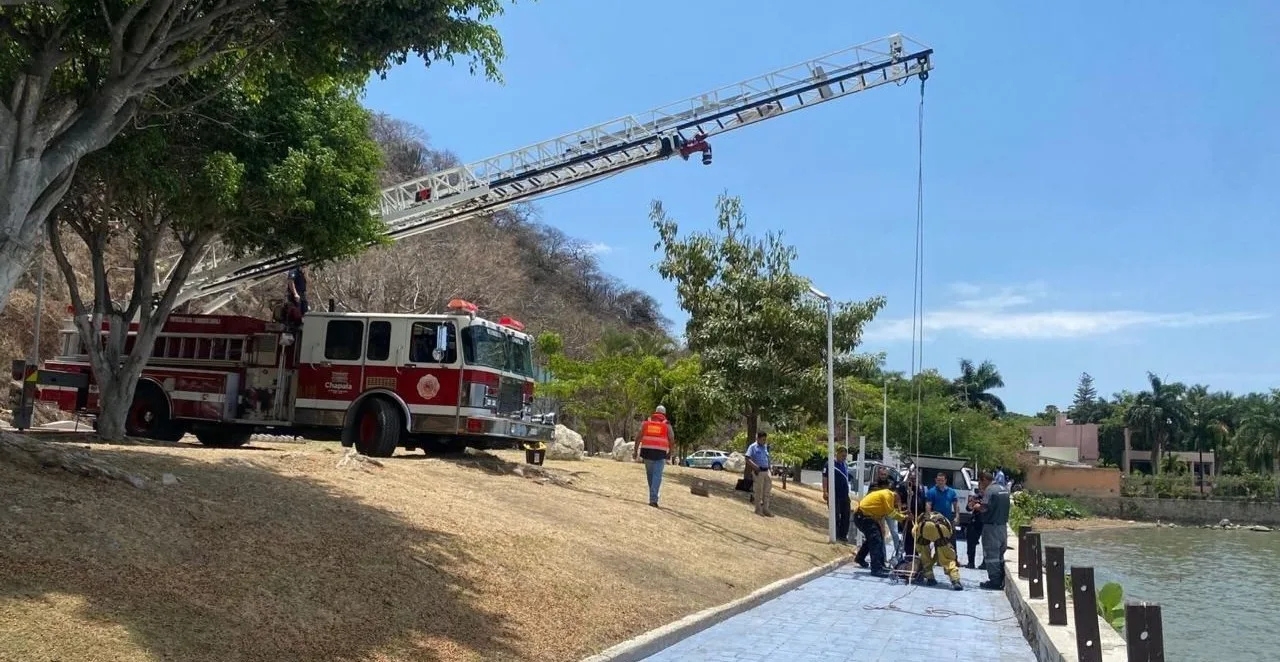 Personal de Protección Civil y Bomberos utiliza una grúa para rescatar el cuerpo del hombre localizado en el lecho del lago, a la altura del parque La Milagrosa, en Chapala