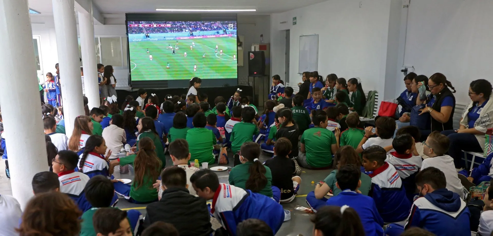 Estudiantes dentro de un plantel escolar presenciando un partido televisado de fútbol. Foto: Cortesía.