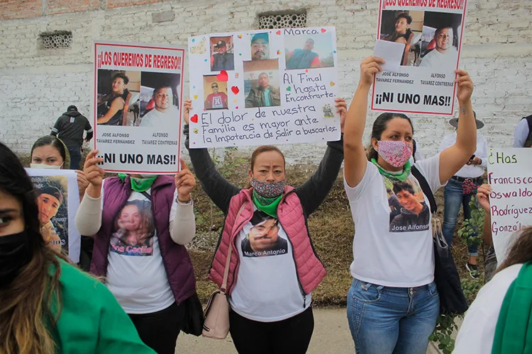 Tres mujeres sostienen cartulinas con mensajes y fotografías de familiares desaparecidos. / Imagen con fines ilustrativos.  Foto: Cortesía.