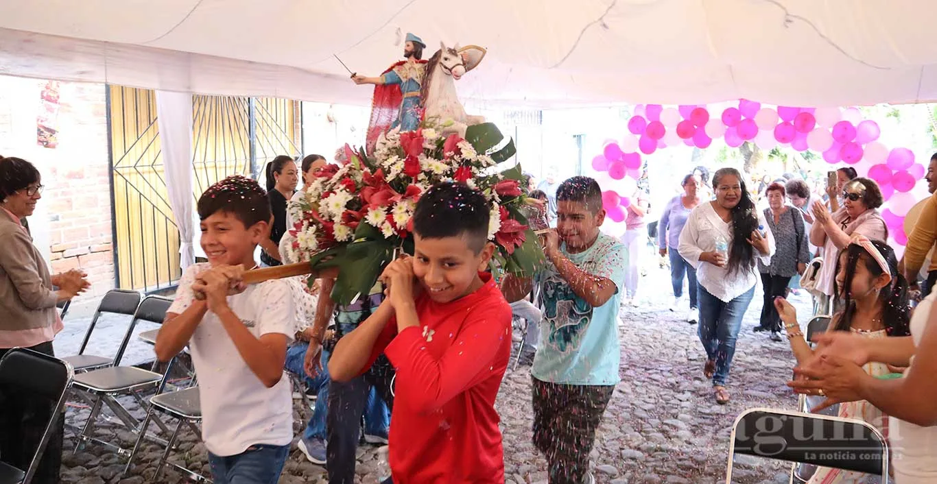 Niños del barrio cargan la imagen de Santo Santiago a su llegada al punto de reunión. Foto: Sofía Medeles.