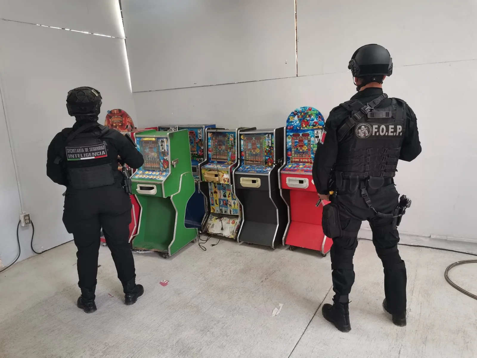 Elementos de la Secretaría de Seguridad de Jalisco resguardan máquinas tragamonedas aseguradas durante el operativo. Imagen ilustrativa.