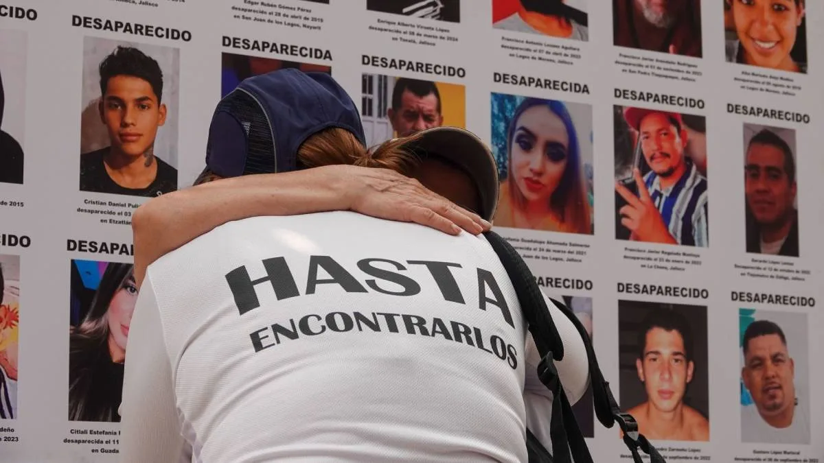Personas que buscan a familiares frente a fichas de búsqueda. Foto: Cortesía.