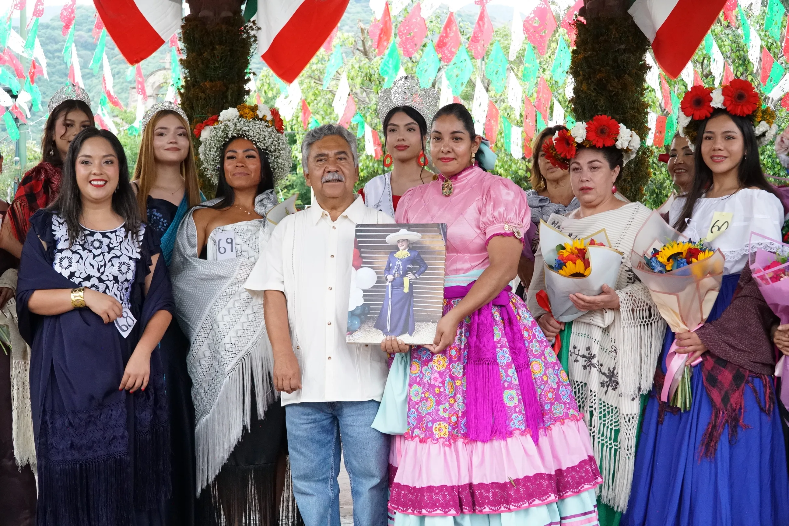 El encargado de despacho, Jesús Escamilla, y la organizadora Eriika Navarro, quien sostiene una fotografía de Talea Klein, homenajeada durante la exhibición tras su fallecimiento días antes. Foto: María Di Paola Blum.